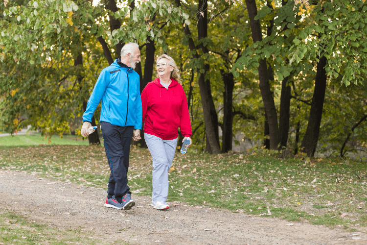 Senior couple enjoys time outside walking the grounds at Bella Vita.